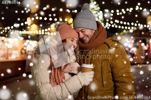 Image of happy young couple with coffee at christmas market
