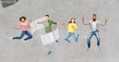 Image of happy people or friends jumping in air over gray