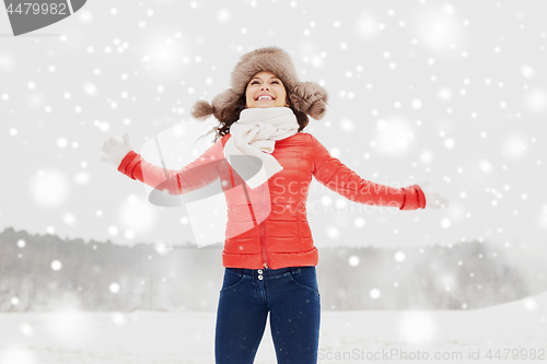 Image of happy woman in winter fur hat having fun outdoors