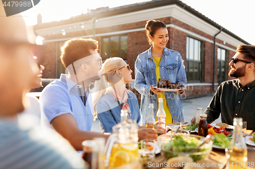 Image of friends at barbecue party on rooftop in summer