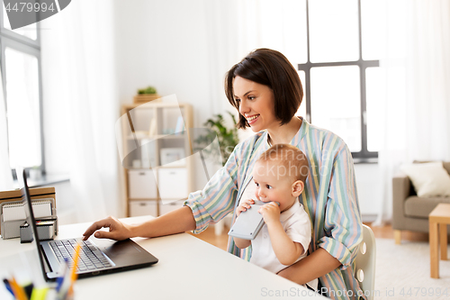 Image of working mother with baby boy and laptop at home