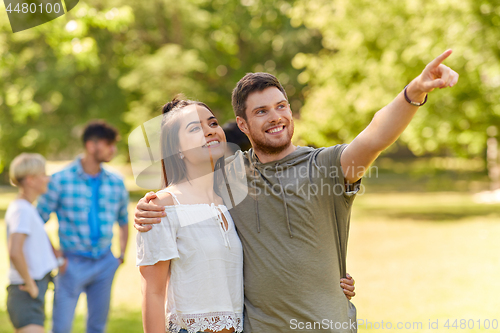 Image of happy couple looking at something in summer park