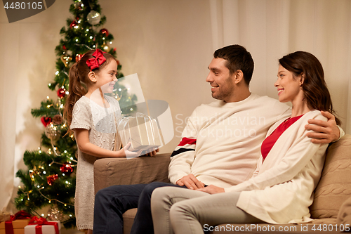 Image of happy family with christmas present at home