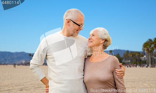 Image of happy senior couple hugging over venice beach