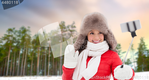 Image of happy woman taking selfie over winter forest