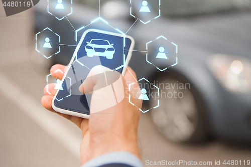 Image of businessman hand with smartphone car sharing app