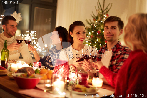 Image of happy friends celebrating christmas at home feast