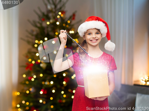 Image of smiling girl with christmas gift and magic wand