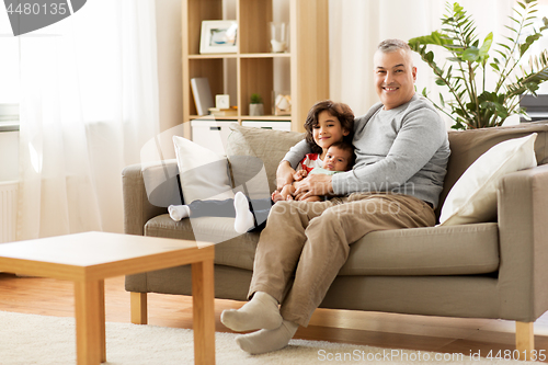 Image of happy father with preteen and baby son at home