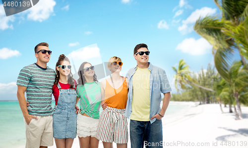 Image of friends in sunglasses over exotic beach background