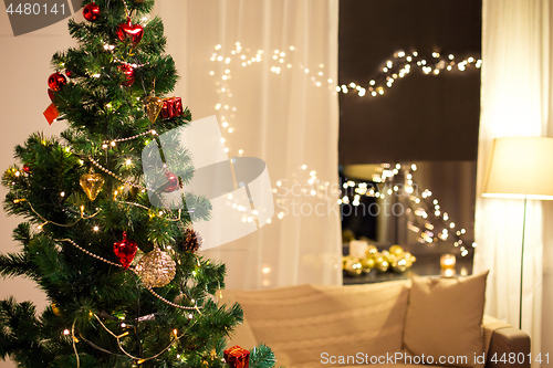 Image of close up of christmas tree at home in evening