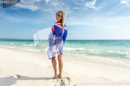 Image of Smiling woman with Australian flag wrapped around her body sunny
