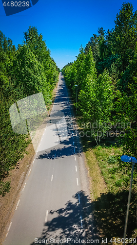 Image of Aerial view of bicycle lane through forest