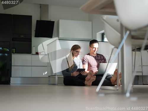 Image of couple using tablet and laptop computers