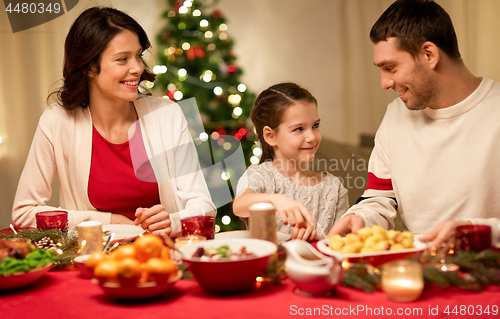 Image of happy family having christmas dinner at home