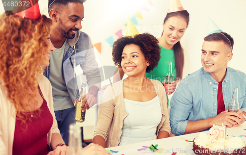 Image of team greeting colleague at office birthday party