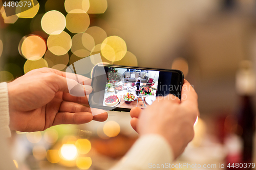 Image of hands photographing food at christmas dinner