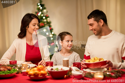 Image of happy family having christmas dinner at home