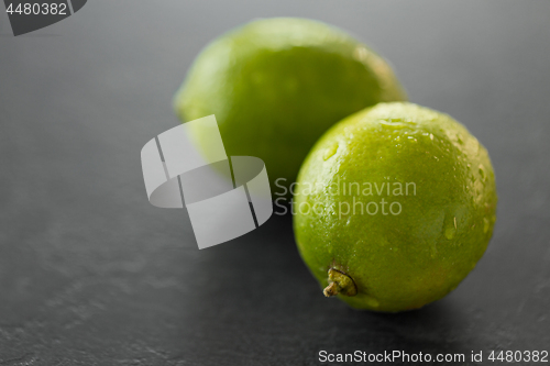 Image of close up of whole limes on slate table top