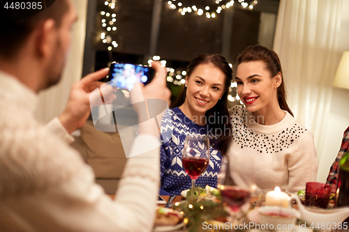 Image of friends having christmas dinner and taking picture