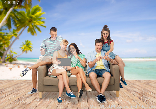 Image of friends with tablet pc and smartphones over beach