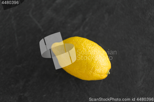 Image of close up of whole lemon on slate table top