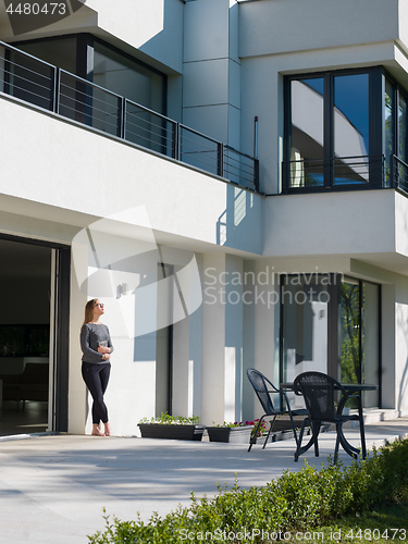 Image of women using tablet computer in front of luxury home villa