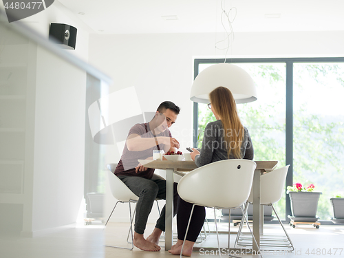 Image of couple enjoying morning coffee and strawberries