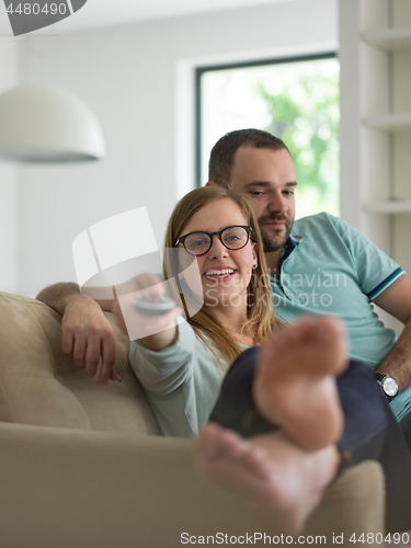 Image of Young couple on the sofa watching television