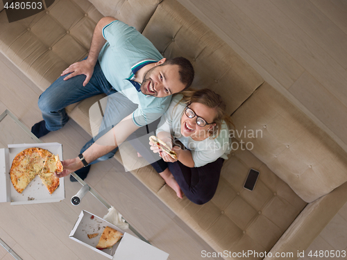 Image of couple eating pizza in their luxury home villa