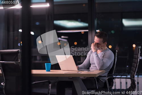 Image of man working on laptop in dark office