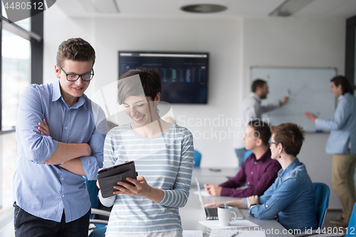 Image of Two Business People Working With Tablet in office