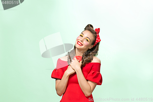 Image of Beautiful young woman with pinup make-up and hairstyle. Studio shot on white background