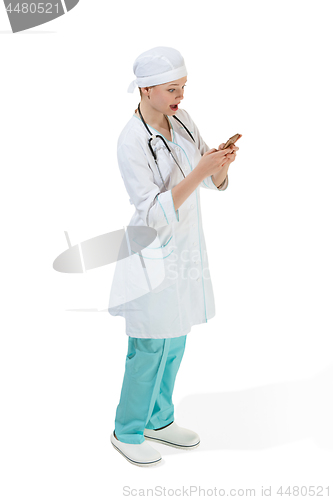 Image of Beautiful young woman in white coat posing at studio. Full length studio shot isolated on white.