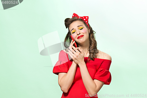 Image of Beautiful young woman with pinup make-up and hairstyle. Studio shot on white background