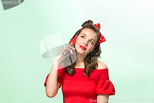 Image of Beautiful young woman with pinup make-up and hairstyle. Studio shot on white background