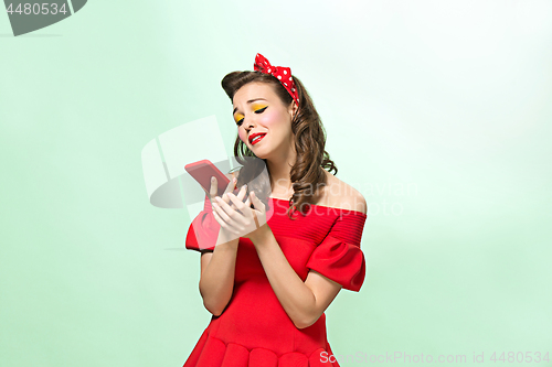 Image of Beautiful young woman with pinup make-up and hairstyle. Studio shot on white background