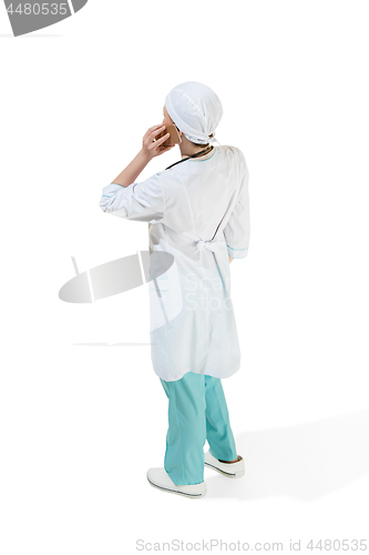 Image of Beautiful young woman in white coat posing at studio. Full length studio shot isolated on white.