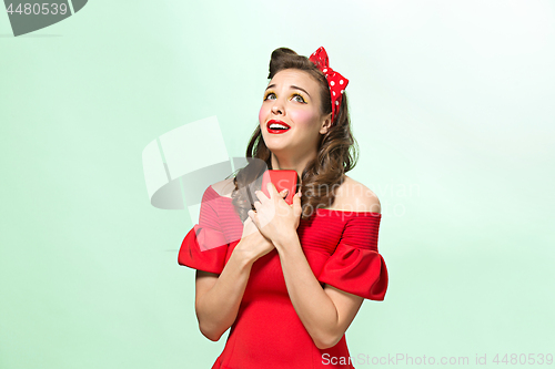 Image of Beautiful young woman with pinup make-up and hairstyle. Studio shot on white background