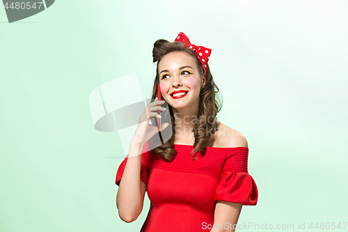 Image of Beautiful young woman with pinup make-up and hairstyle. Studio shot on white background