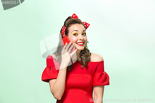 Image of Beautiful young woman with pinup make-up and hairstyle. Studio shot on white background