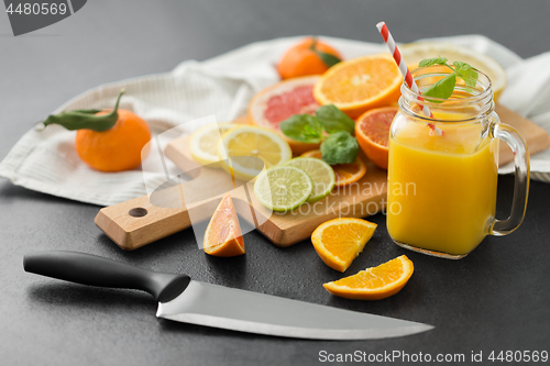 Image of mason jar glass with juice and fruits on table