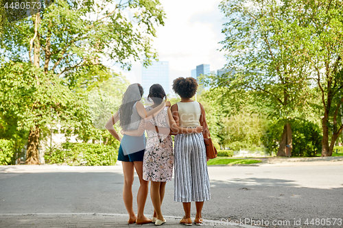 Image of young women or friends hugging at summer park