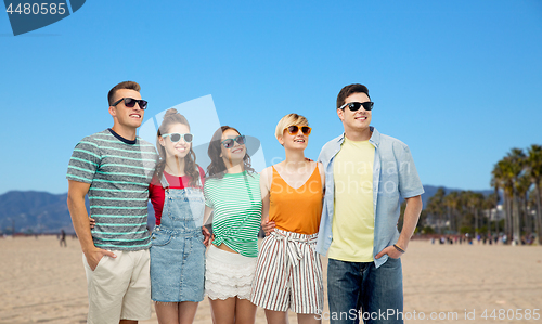 Image of happy friends in sunglasses over venice beach