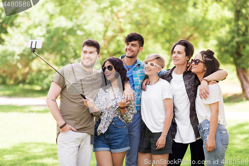 Image of friends taking picture by selfie stick at summer