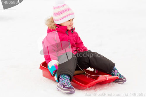 Image of happy little girl on sled outdoors in winter