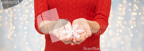 Image of close up of woman in red sweater holding snowflake