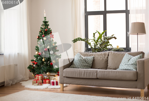 Image of christmas tree, gifts and sofa at cozy home