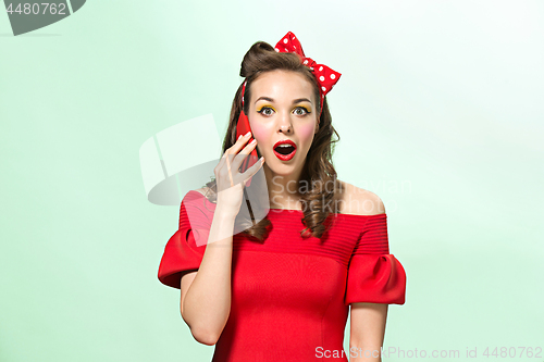 Image of Beautiful young woman with pinup make-up and hairstyle. Studio shot on white background