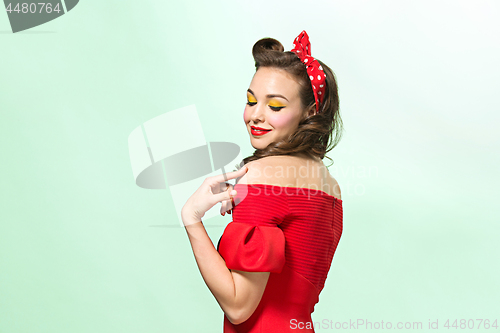 Image of Beautiful young woman with pinup make-up and hairstyle. Studio shot on white background